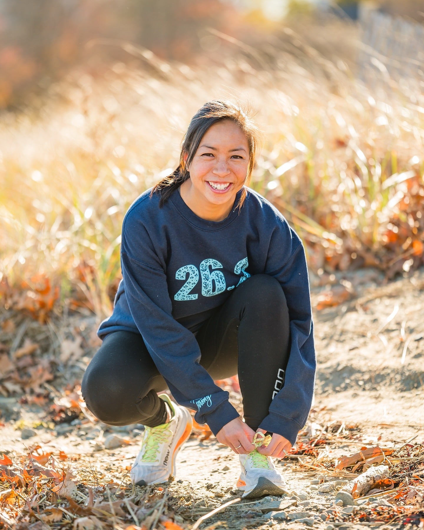 Pen and Paces founder Cindy Smith kneeling to tie her shoe
